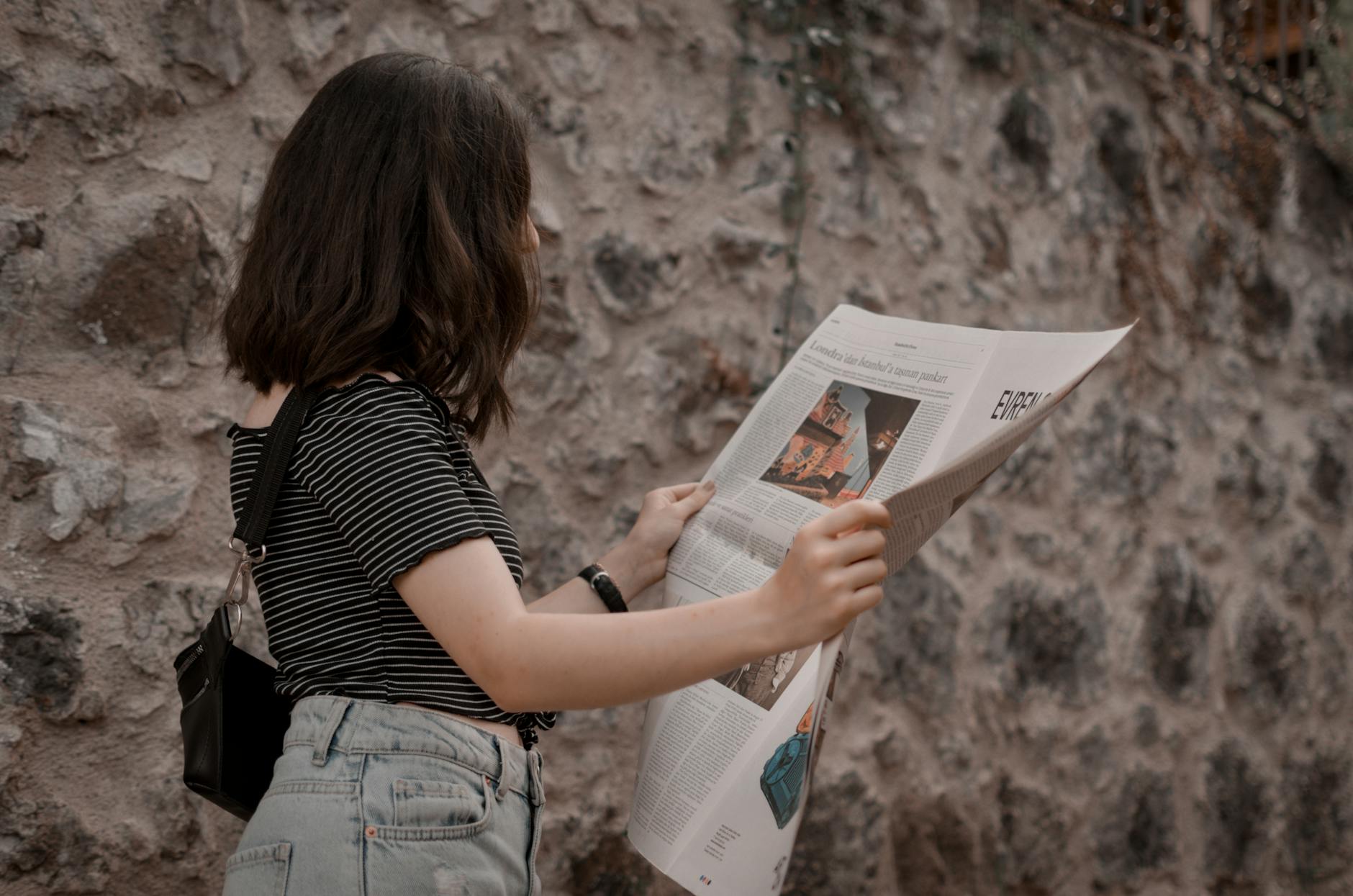 photo of woman reading newspaper